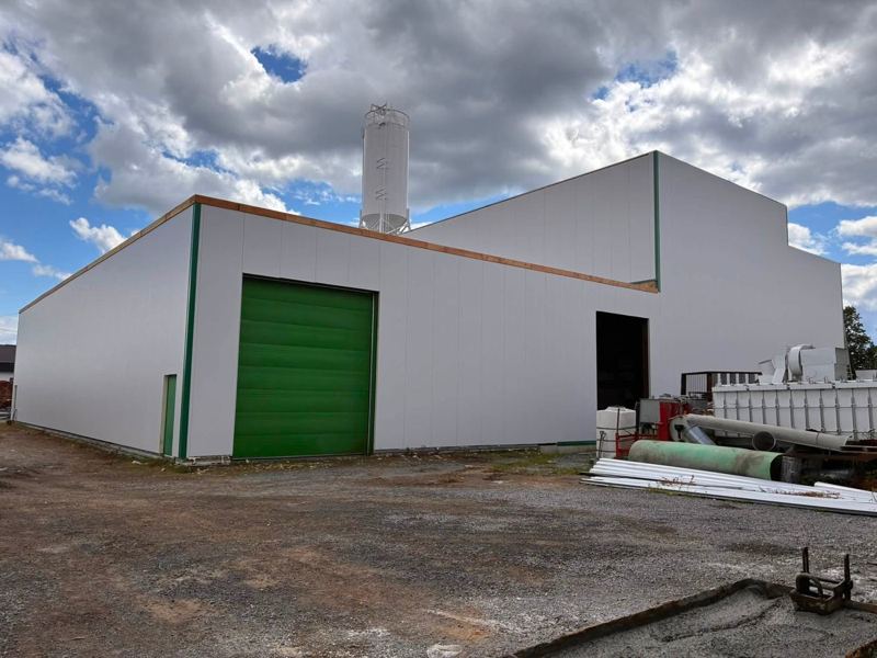 Bâtiment industriel recouvert de panneaux isolés blancs, projet terminé