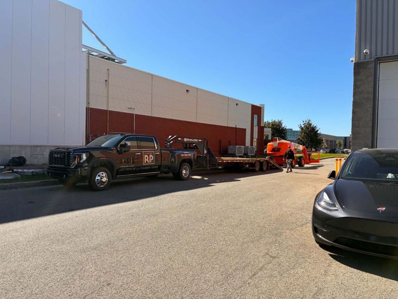 Camion des Industries RP avec remorque et nacelle, en livraison sur un chantier
