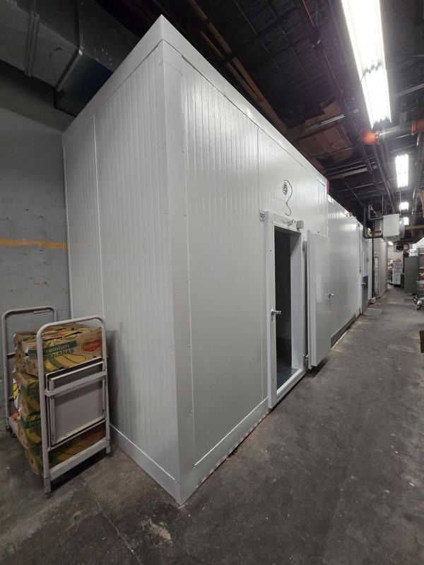 Chambre froide en panneaux isolés blancs installée dans un corridor d’entrepôt alimentaire