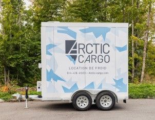 Remorque réfrigérée Arctic Cargo stationnée devant une haie d’arbres