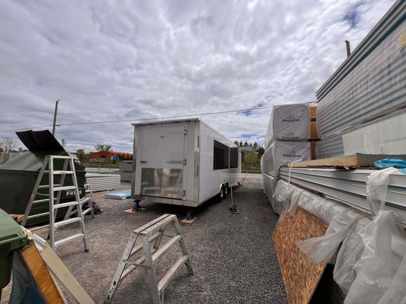 Remorque réfrigérée terminée dans la cour, près des palettes de panneaux isolés